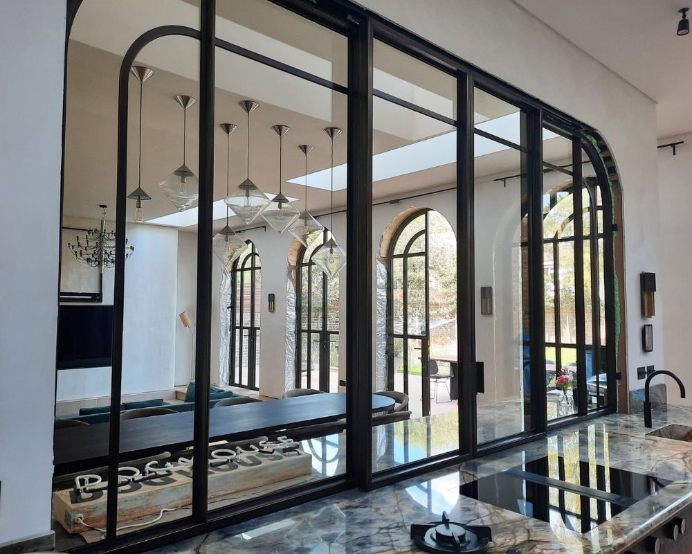 Internal arched steel framed sliding glass window system to modern extension