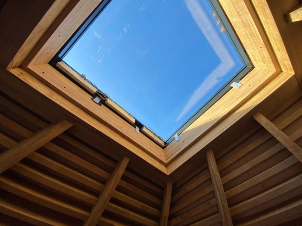 an internal view of a large opening rooflight in a timber roof