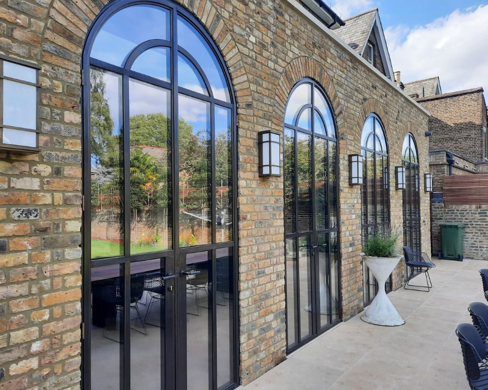 Parisian style steel framed glass doors to rear extension at Mortlake Road in Kew