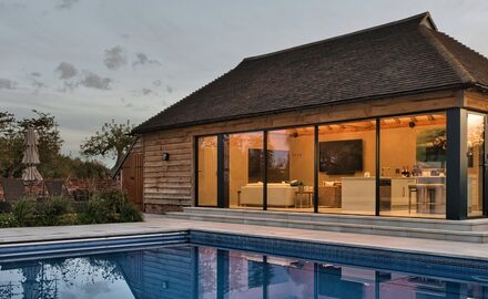 exterior view of a highly glazed pool house with sliding and bifolding doors