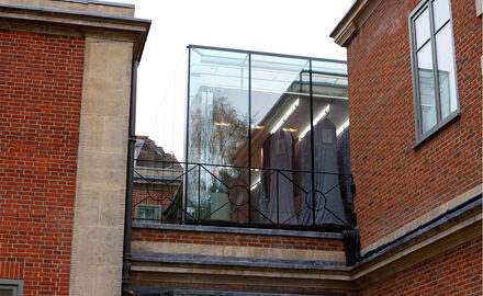 Large frameless glass box extension with glass link to store historical dress collection
