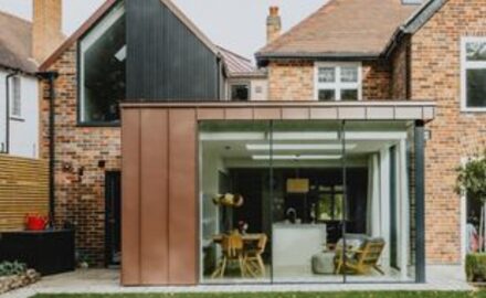 glass kitchen extension with slim glass doors and brown metal cladding