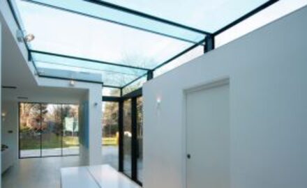 a large glass roof over a side infill extension with white walls
