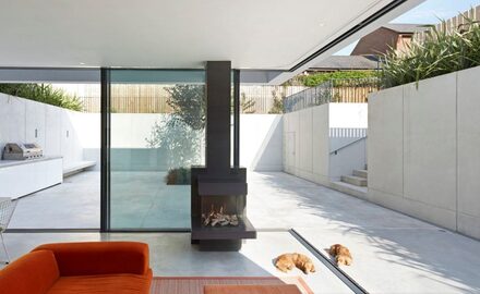 opening corner sliding glass doors with chimney to outdoor courtyard