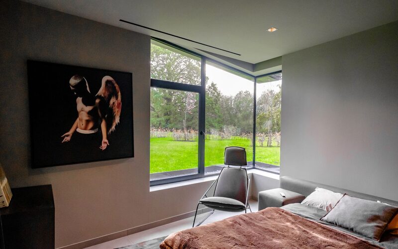 a corner bedroom window made from frameless glass with an integrated opening window