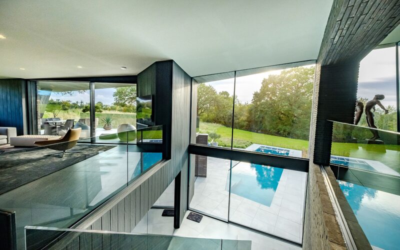 double height glass wall with sliding doors to base and fixed glass above