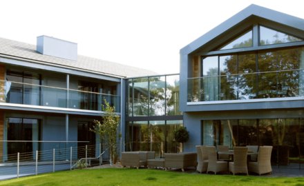 rear view of a sustainable home design with frameless glass walls