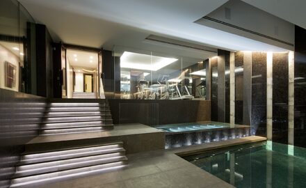 Internal basement swimming pool with heated glass walls and balustrades