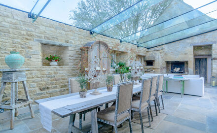 large frameless glass roof with glass beams to rustic garden extension
